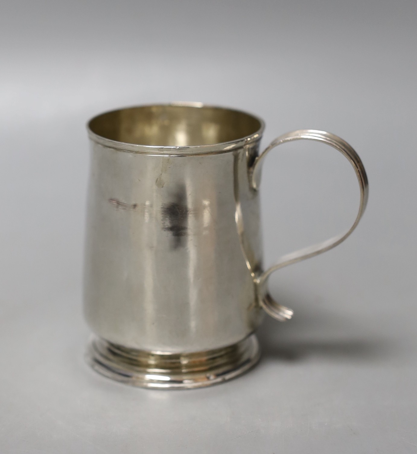 A small late George I silver mug, with reeded handle, by George Greenhill Jones, London, 1725, 77mm, 112 grams, (a.f.).